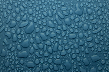 Fresh water drops on grey dim cold blue background as elegant pattern of different form drops, texture in modern elegant style, top view.