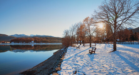 Obraz premium winter evening scenery, snowy lake shore Walchensee, recreational area with benches