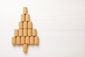 Christmas tree made of wine corks on white wooden table, top view. Space for text