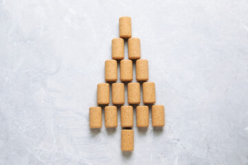 Christmas tree made of wine corks on light grey table, top view