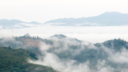 Aerial view of clouds on beautiful mountains that covers the fertile tropical forests South of Thailand.