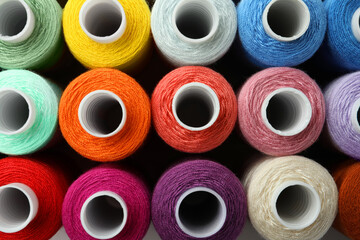 Set of different colorful sewing threads as background, top view