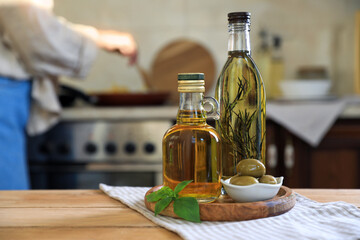 Different cooking oils and ingredients on wooden table indoors. Space for text