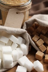 White and brown sugar on wooden table, closeup