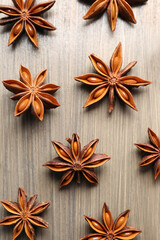 Aromatic anise stars on wooden table, flat lay