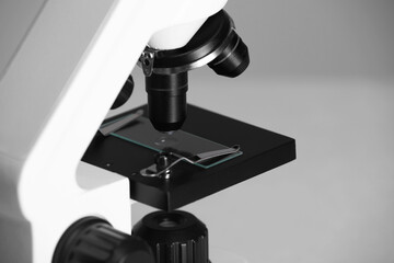 Modern microscope on grey background, closeup. Medical equipment