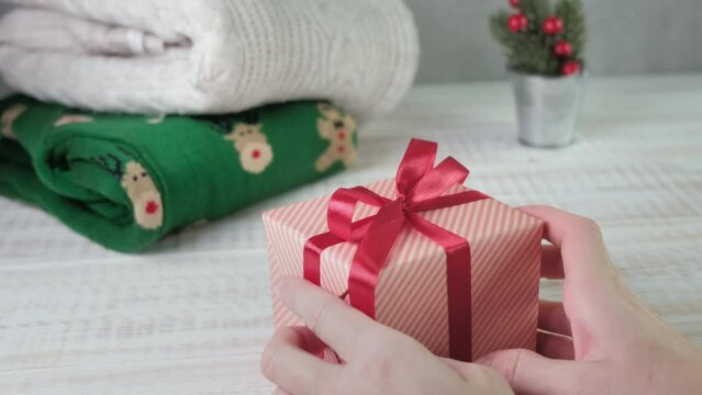 Asian girl wrapping gift box with red ribbon in Christmas Day.