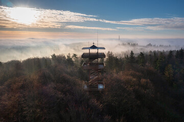 Beautiful landscape of Kashubia with a misty sunrise with a lookout tower in Wiezyca, Poland