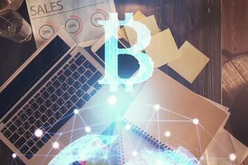 Blockchain theme hologram drawings over computer on the desktop background. Top view. Double exposure.