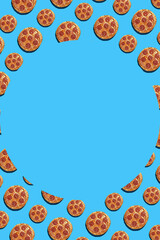 A hard light pattern of whole big and small salami pizza pieces on a seamless bright blue background, top view, round circle shaped space for text