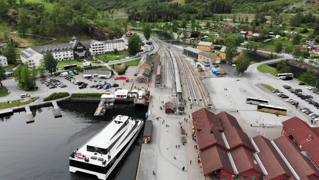 Aerial: flying over the Fl&aring;m harbour among mountains, over the town and the station