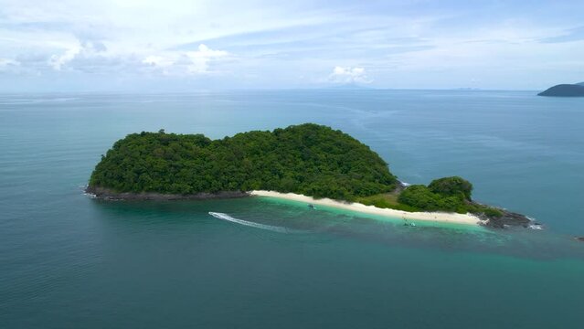 Arcing shot of a speedboat taking tourists to the stunning Beras Basah Island, Malaysia