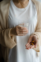 Depressed woman holding a glass of water, suffering from headaches.