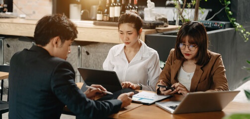 Businesswomen work and discuss their business plans. A Human employee explains and shows her colleague the results paper in office..