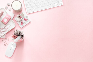 A feminine workspace, keyboard of a computer on pink background with copy space