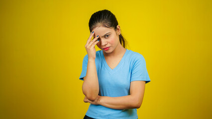 Young beautiful woman over isolated yellow background suffering from headache desperate and...