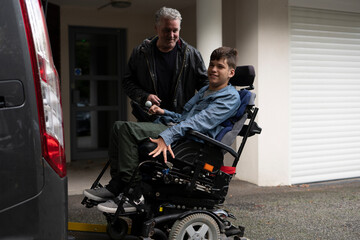 Father and disabled son using wheelchair lift 