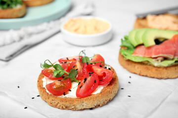 Tasty rusks with different toppings on white table, closeup