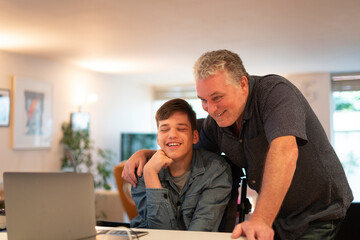Father using laptop with son