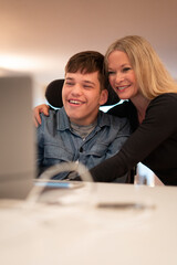 Mother and disabled son using laptop