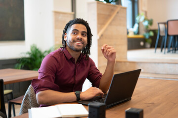 Smiling businessman working on laptop in office © Cultura Creative