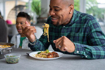 Man eating dinner with family © Cultura Creative