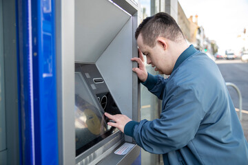 Naklejka na ściany i meble Man using cash machine in street