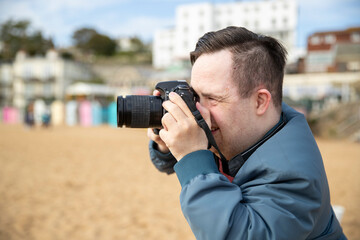 Mid adult man taking pictures on beach - Powered by Adobe