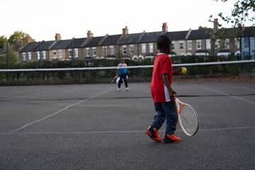 Children playing tennis on neighborhood court