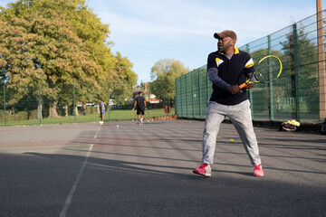 Man playing tennis on neighborhood court