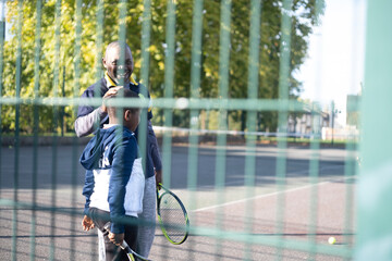 Tennis coach and boy meeting on neighborhood court