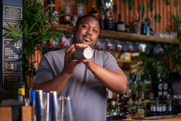Portrait of bartender preparing cocktail at bar