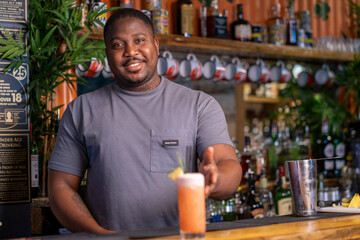 Smiling bartender serving cocktail