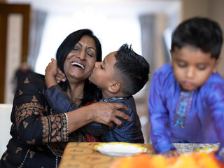 Boy kissing grandmother during Diwali celebration