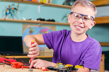 The boy is fixing the drone. Primary technical education.