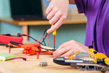 The boy is fixing the drone. Primary technical education.
