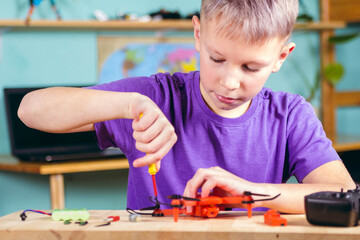 The boy is fixing the drone. Primary technical education.