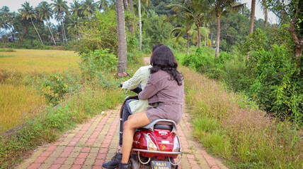 A young lovely attractive romantic Indian couple looking at each other, embracing, smiling, cuddling. Romantically and hopelessly in love. Indian couple o a rented two wheeler roaming in Goa. 