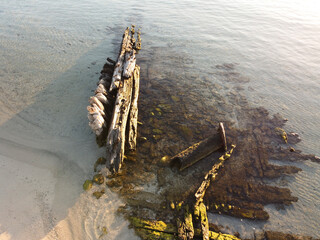 Drone view of the ship's remains in the "beach of the wreck" on the island of Caprera at sunrise, La Maddalena National Park, Sardinia