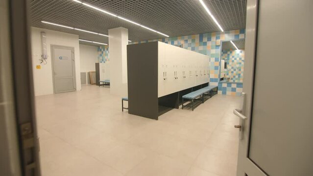 Locker room with cabinets benches and showers in contemporary sports center. Empty dressing room for sportsmen in gym