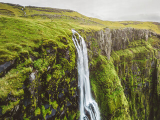Fototapeta na wymiar Aerial view of the top of the waterfall running over moss covered rocks in Iceland 
