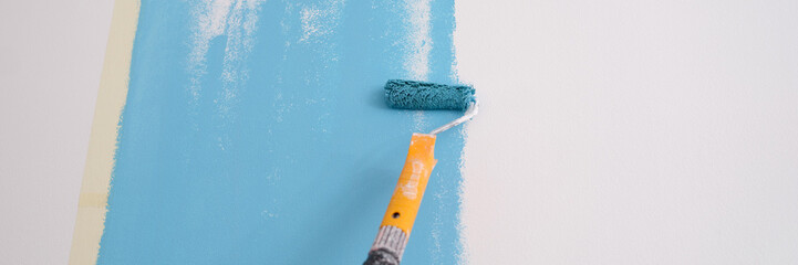 Hand painted wall. Painting walls with roller in blue