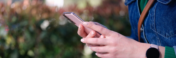 Modern smartphone in female hands on street