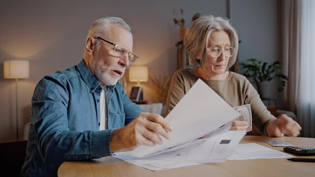 Senior married couple discusses utility bills nervously