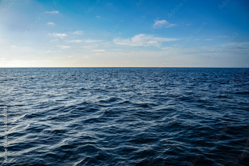 Wall mural bright blue ocean water ripples background on a sunny day. clean water consumption and natural resou