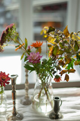 Variety of flowers in a vase on a wooden table in a vintage style room