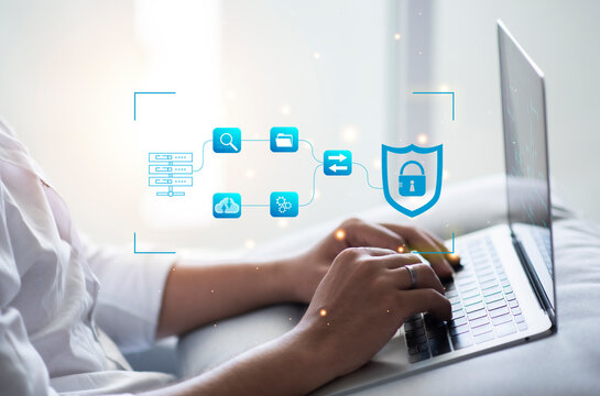 Cybersecurity and privacy concepts to protect data. Young businessman working on his laptop at home, select the icon security on the virtual display.