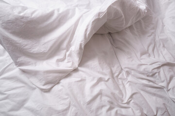 Top view of sheets and pillows. White linens. Bed texture
