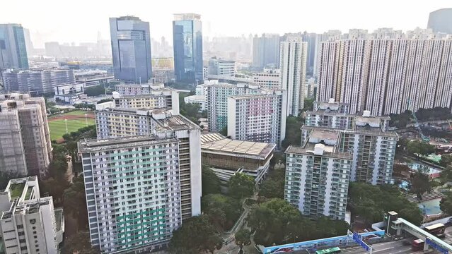 Aerial drone establishing shot over Kai Yip Estate, Kai Yip Recreation Center and Kowloon Bay Sports ground in Hong Kong, China at daytime.