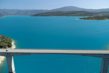 Fototapeta na wymiar Aerial view on blue lake Sainte-Croix-du-Verdon, road bridge and cliffs, tourists destination in France